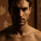 Man with a gold necklace against a dark background